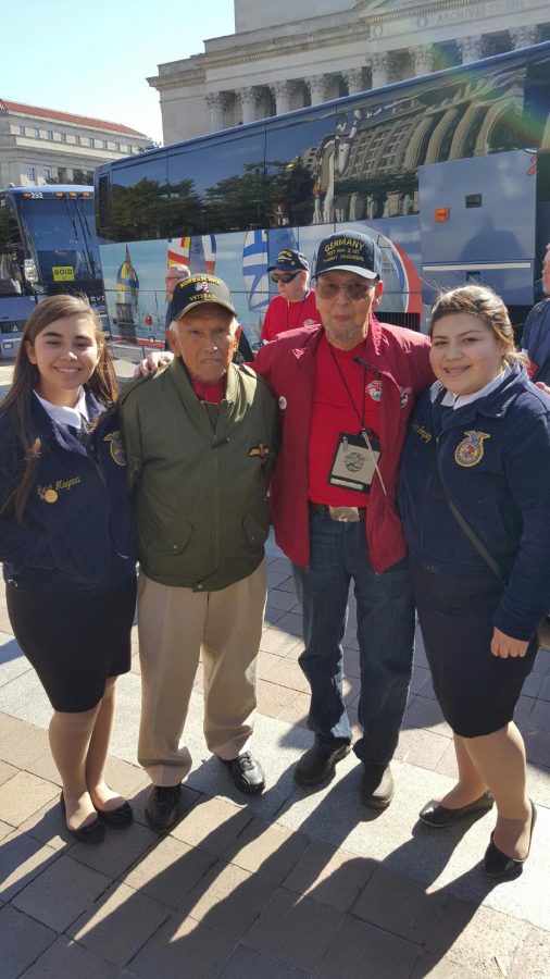 Los Banos FFA members Juliet Magana (left) and Belen Gonzalez (right) stand with Honor Flight Veterans at the National Navy Memorial in downtown Washington DC.