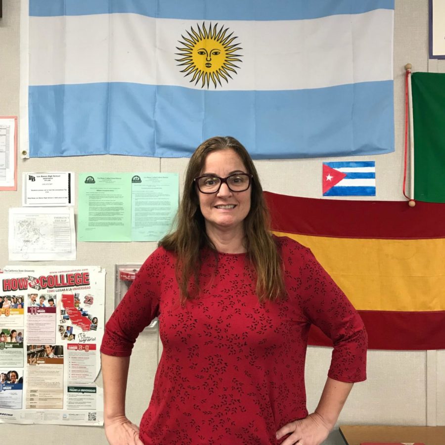 Mrs. Curutchague poses in front of her blue and white Argentina flag.