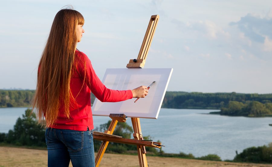 Girl begins a painting of the beautiful scenery. 