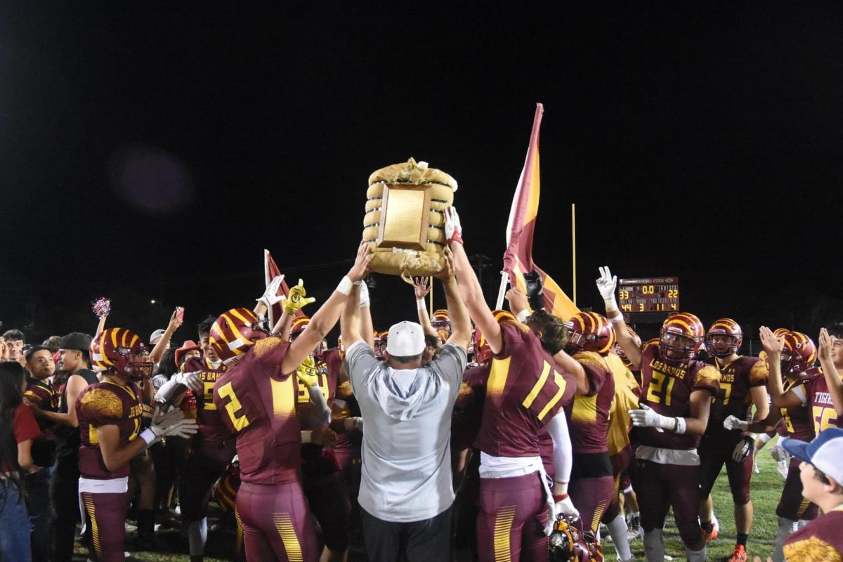 Coach Caropeso holds the Hay trophy in front of the team after they take the win against DP.