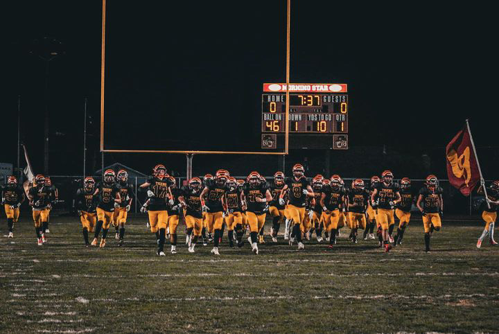 The Los Banos Tigers run onto the field to face the Mountain House Mustangs.