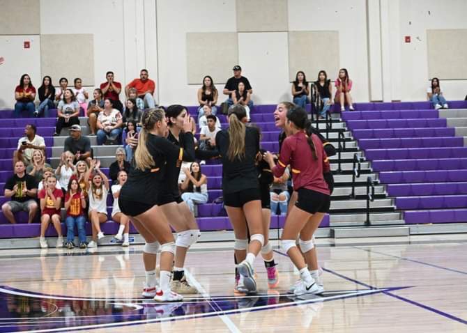 Varsity girls volleyball team celebrates a successful pass.