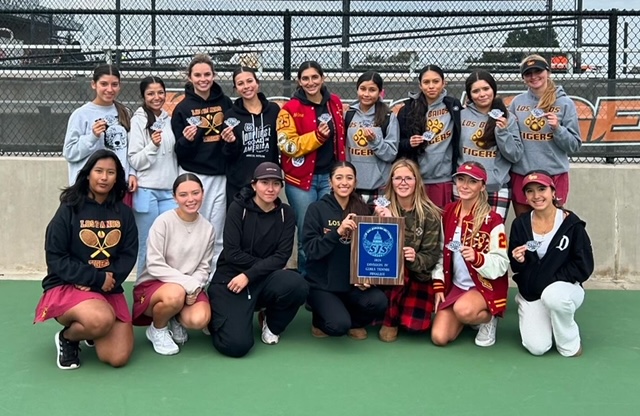 The 2024-25 Varsity Girls Tennis team holding up their finalist patches after competing at UOP.