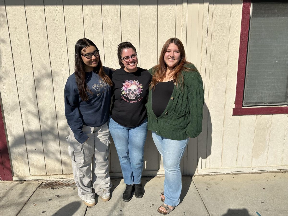 Amairany Gomez and Evelyn Marisca with  Advisor Mrs. Teixeira get ready for Battle of Books competition. 