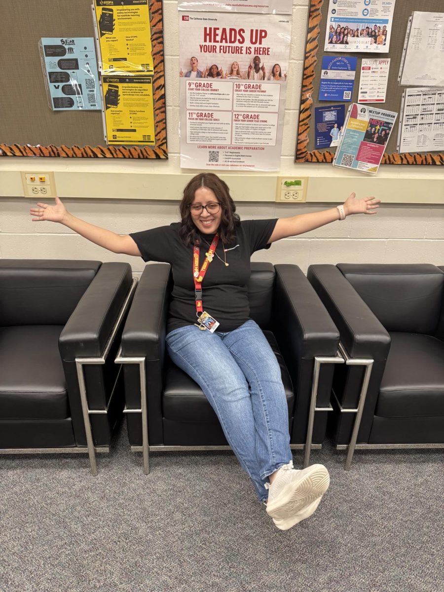 Mrs. Vazquez sits in front of CSU poster.
