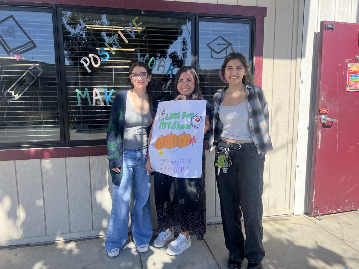 Ms. Sagouse and Art Club officers proudly show off Fall Art Show posters.