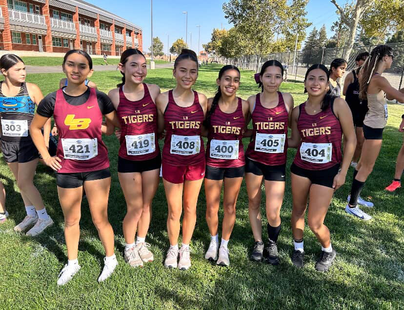 Girls cross country varsity team pose before a meet.