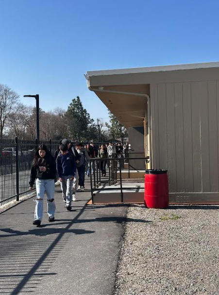 Students walk in a narrow path through the portables. 