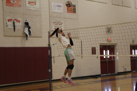 Khazi Aguinaldo spikes a volleyball over the net.